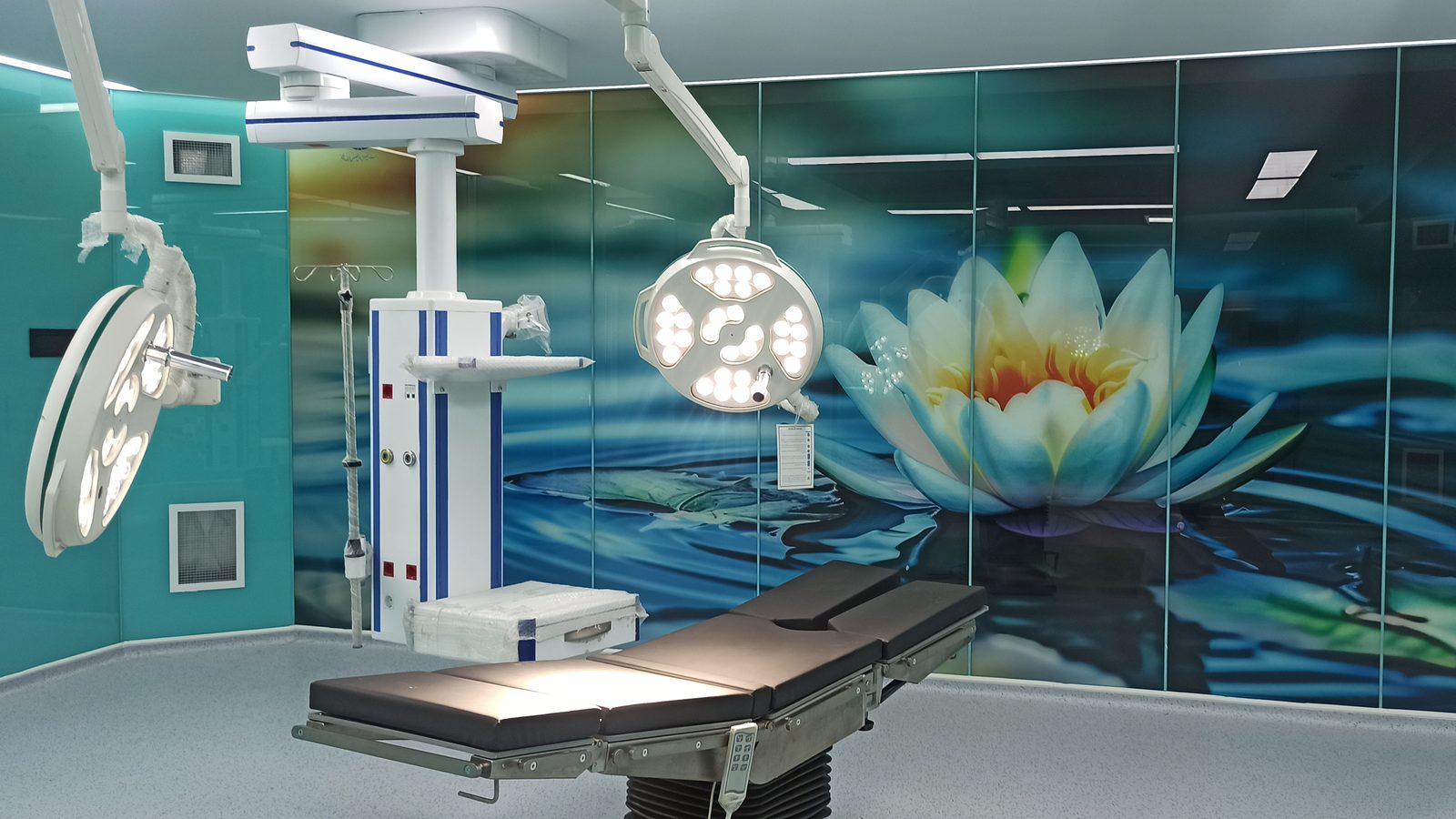 Operating room with surgical pendant, surgical lights and a lotus graphic wall panel