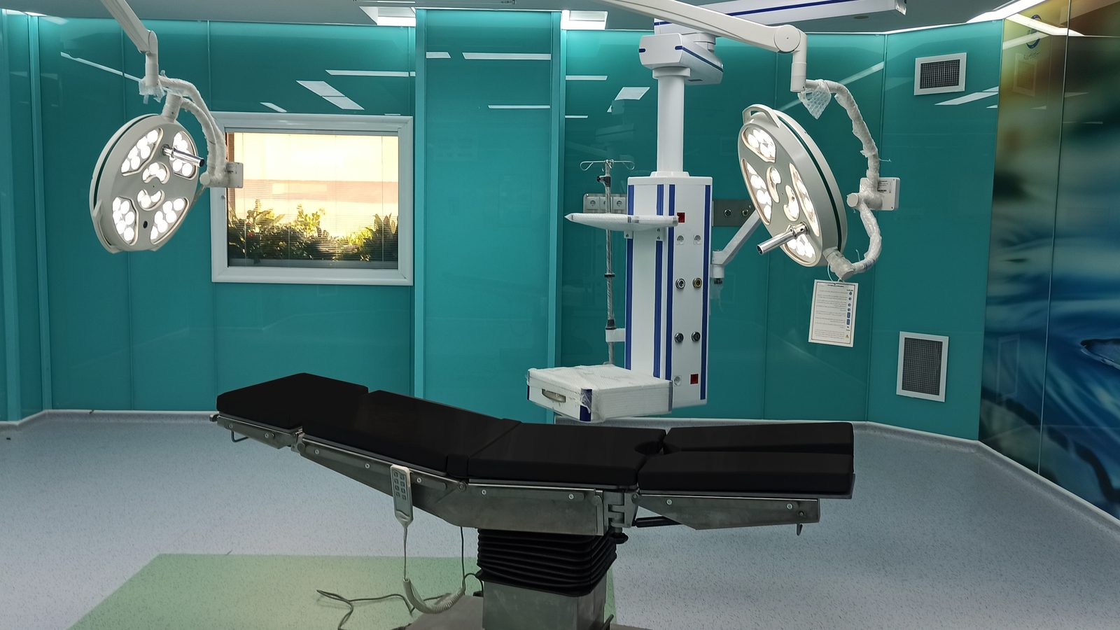 Operating room with surgical table, two surgical lights and a ceiling pendant